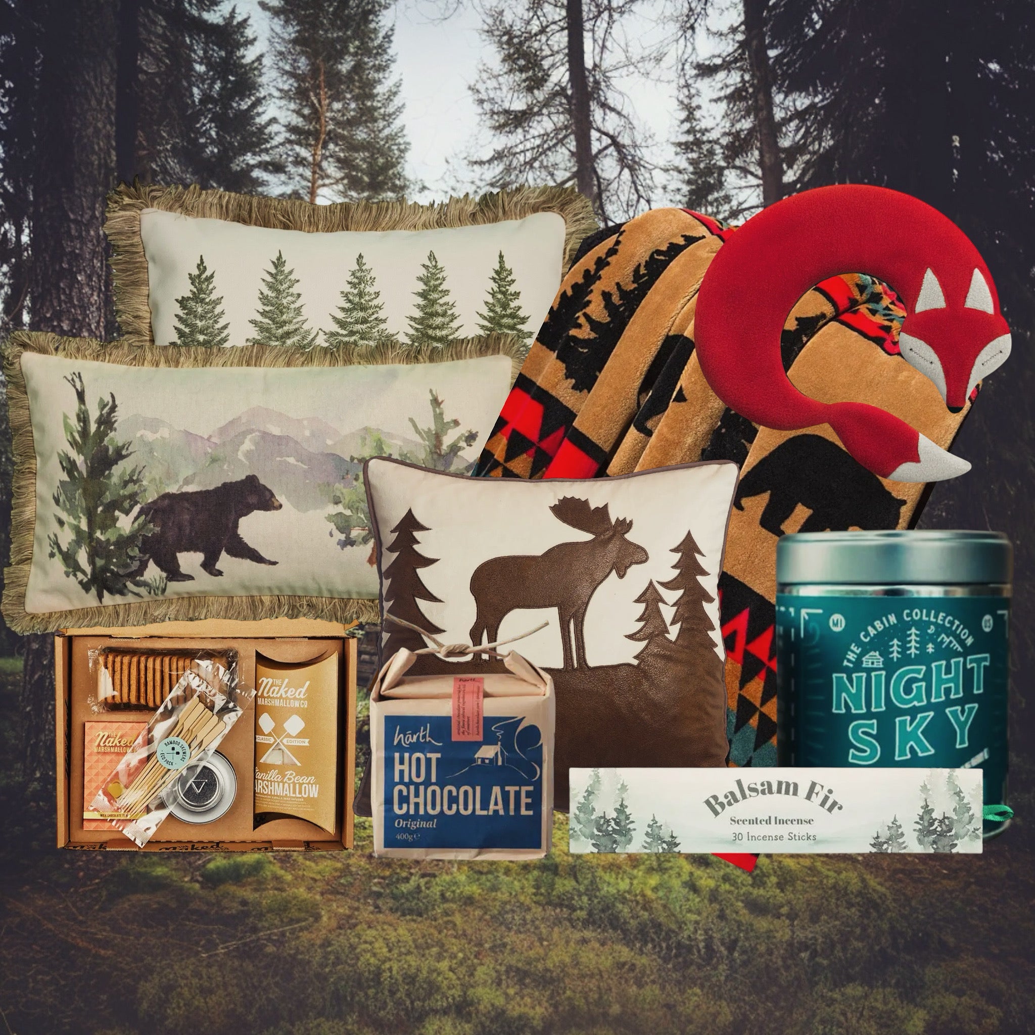 Holiday gift set with cozy socks, fox neck pillow, animal print scarf, candle, tea tin, and hot chocolate box by the fireplace.