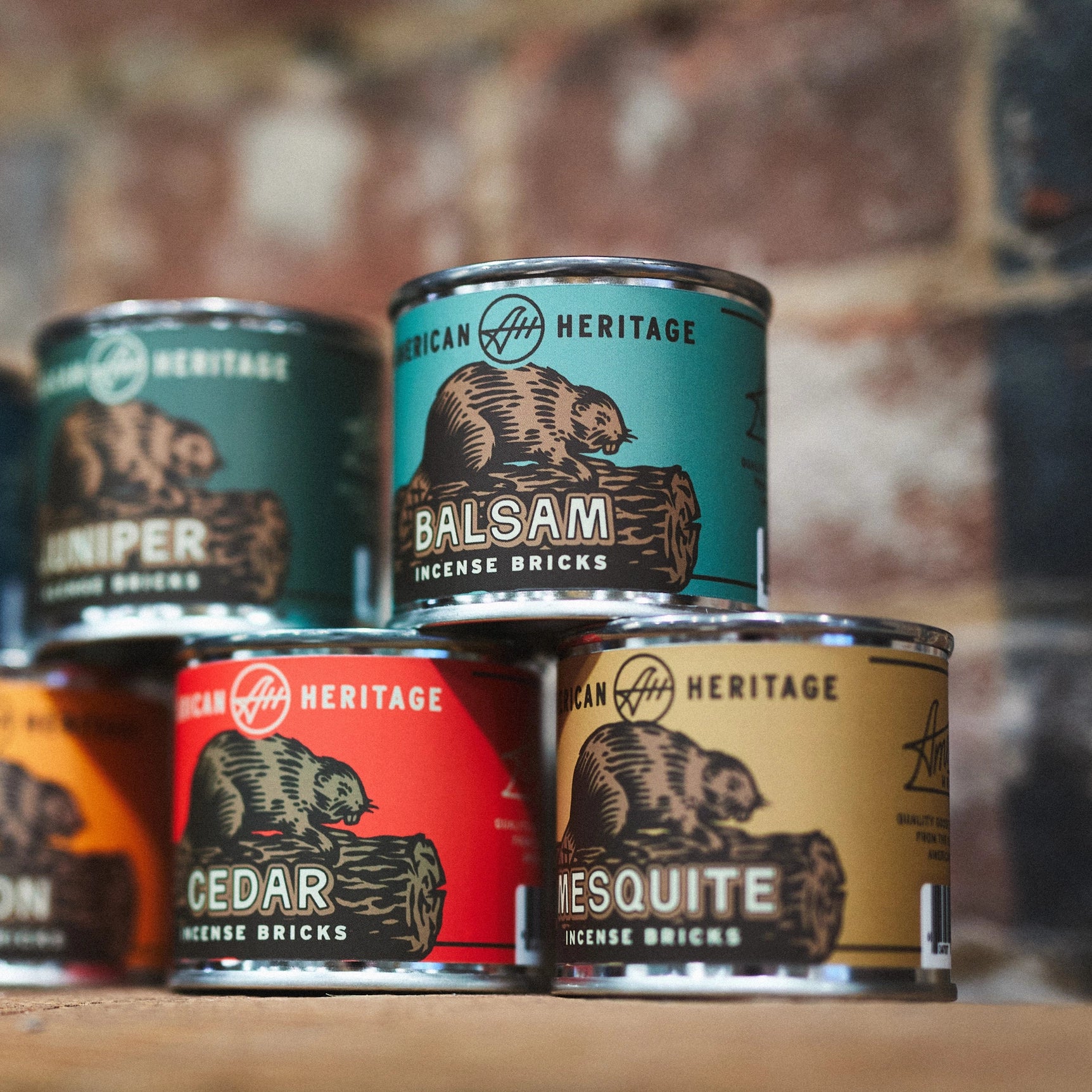 Four Piñon 20 Incense Bricks cans by American Heritage Brands stacked neatly on a rustic wooden shelf for aromatherapy.