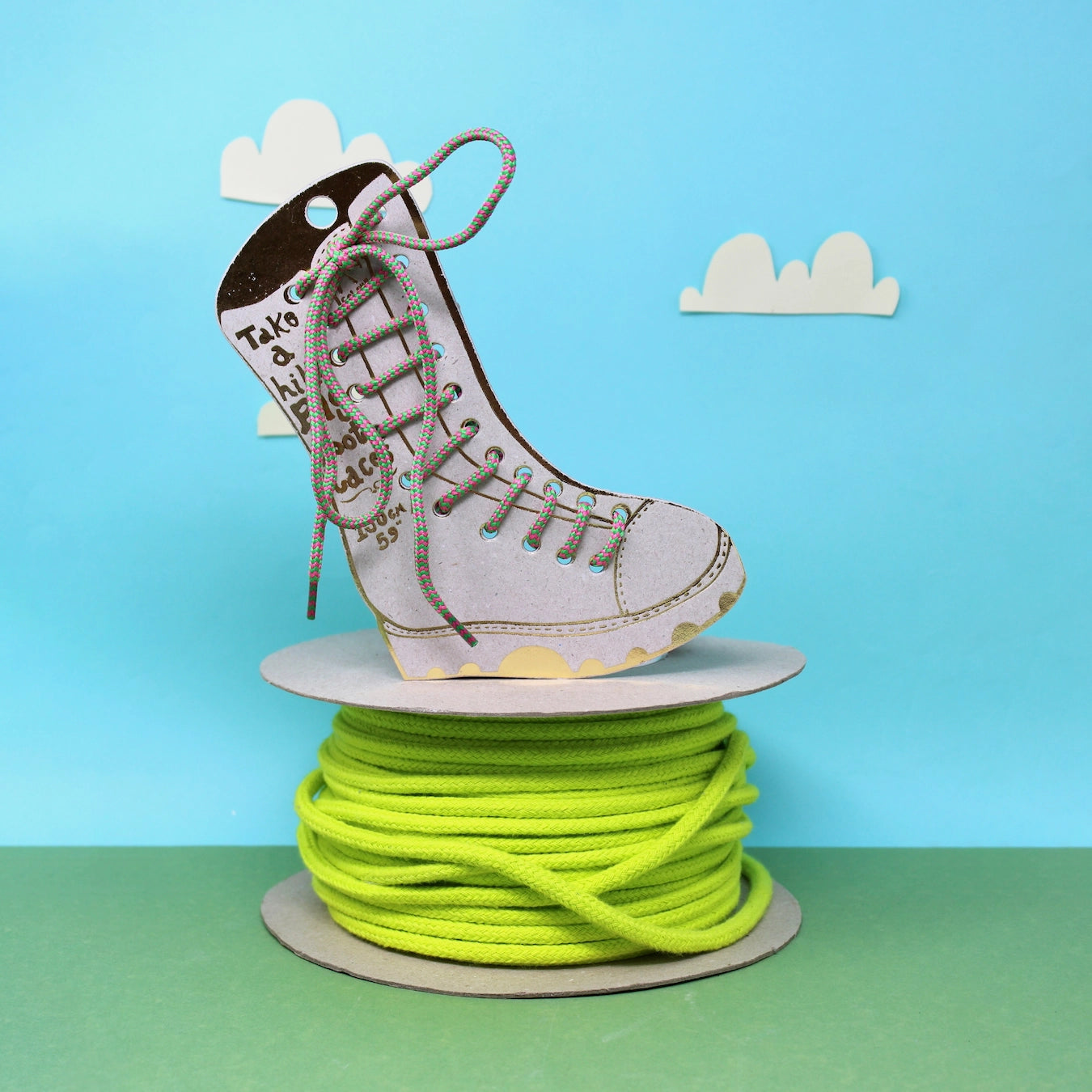 Bright green/pink The Ark Big Boot Laces shown on neon green cord with blue and green Ark branding backdrop—colorful footwear accessory.