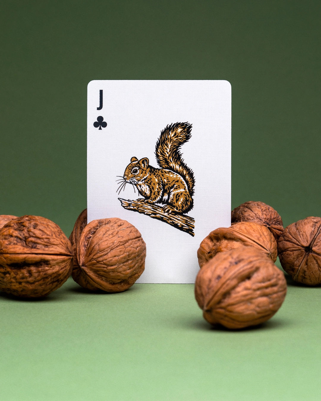 Art Of Play Smokey Bear Jack of Clubs card features a squirrel and walnuts on green, nature-inspired playing card design.