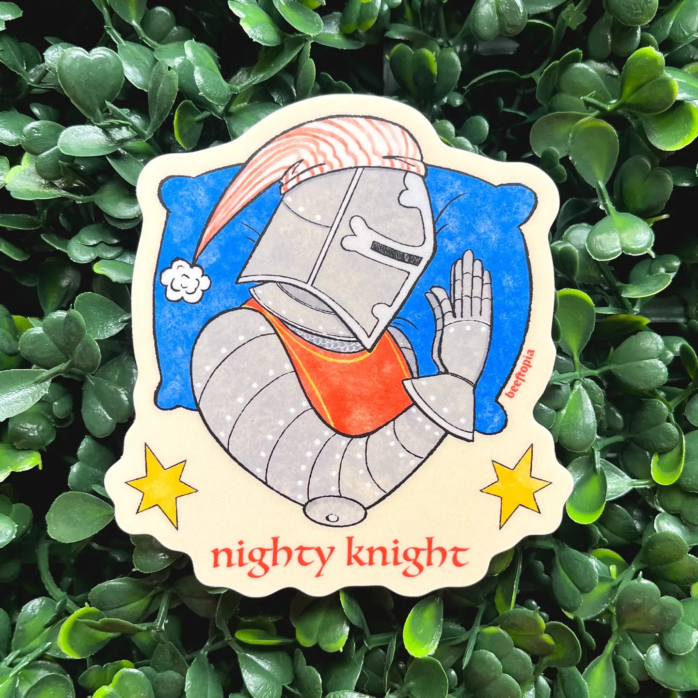 Medieval Beeftopia Nighty Knight vinyl sticker shows a praying knight and "nighty knight" on green leaves; waterproof, unique gift.