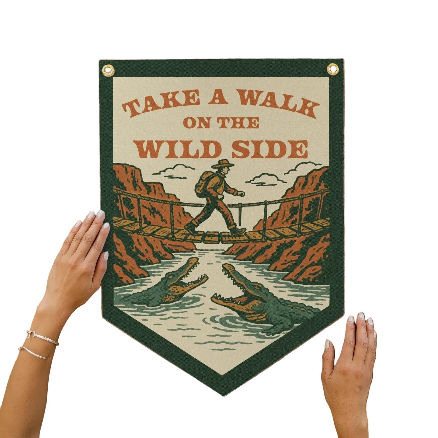 Hand holding Benoit’s Design Co “Take A Walk On The Wild Side” felt pennant with hiker, alligators; adventure decor gift.