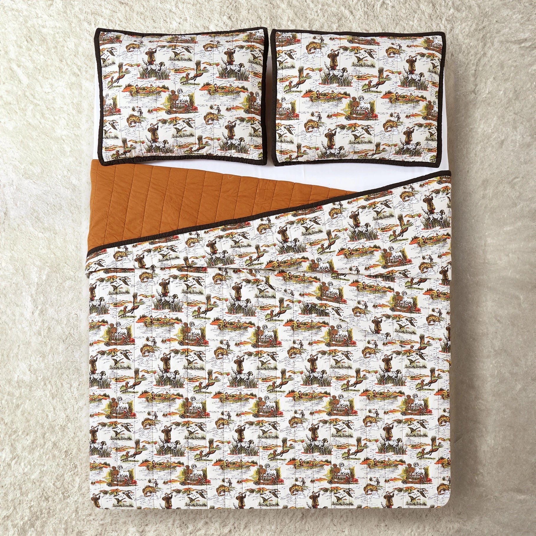 Twin bed with Camp Wandawega Sportsmens Quilt Set, pillows, and lodge-print bedding on a cream rug; cozy cabin bedroom decor.