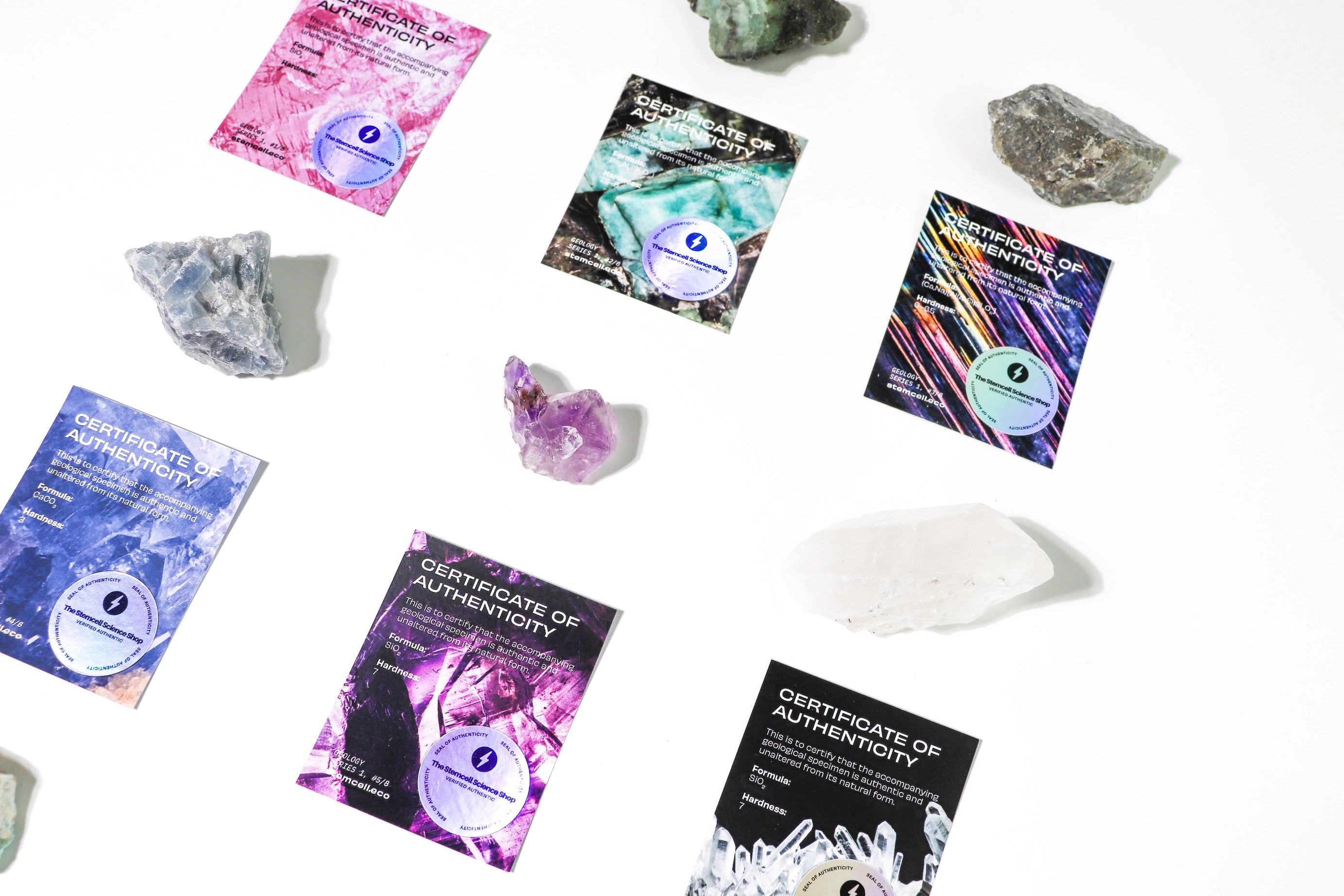 Stemcell Science Geological Crystal Blind Bags: scattered crystals and vibrant certificates displayed on a clean white background.