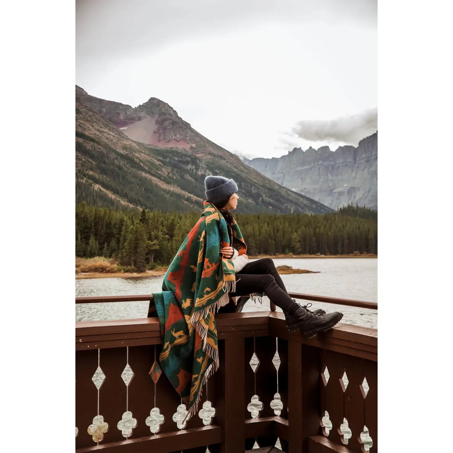 Introducing the Sackcloth & Ashes Smokey Bear Blanket - Smokey Wild: a uniquely crafted blanket featuring a vibrant forest and wilderness pattern adorned with mountains, wildlife, and trees in blue, red, and yellow hues. This special piece promotes wildfire prevention while being thoughtfully made from recycled materials.