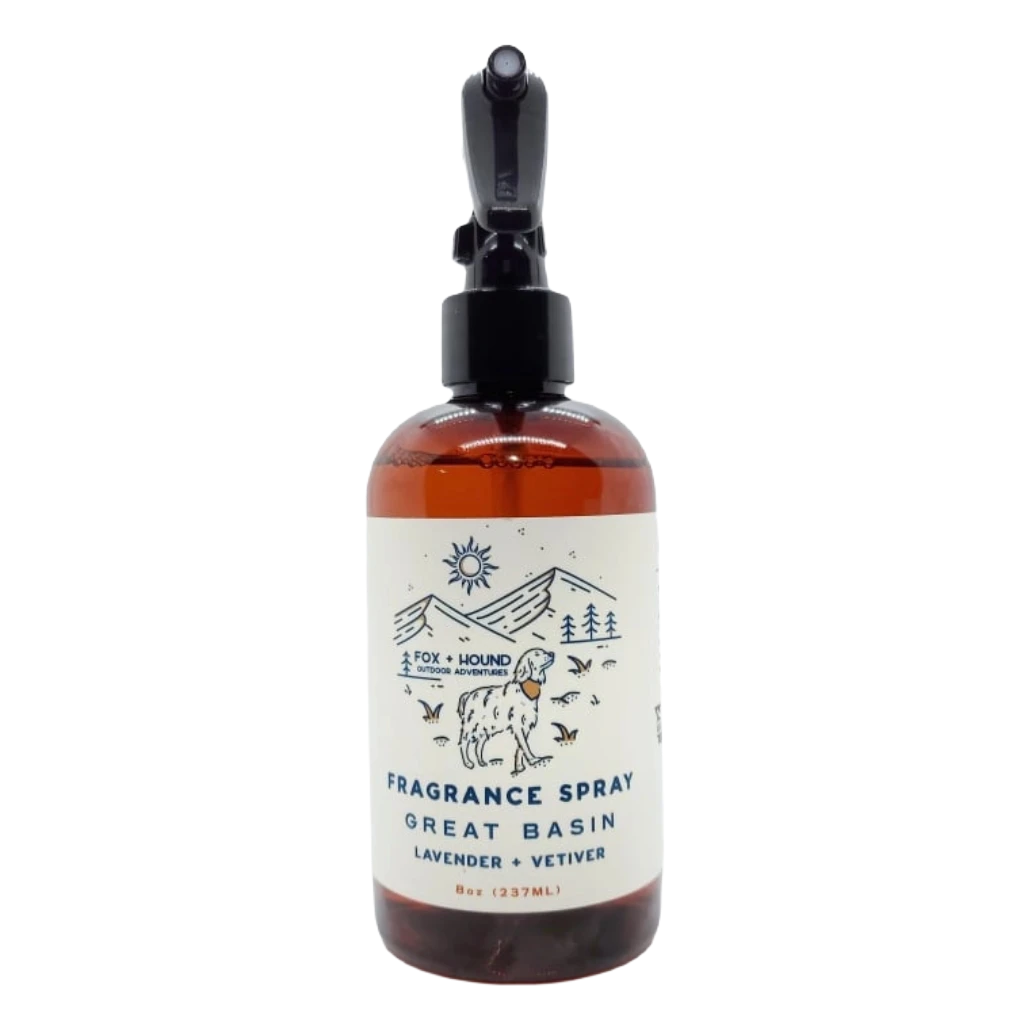 Amber bottle of Fox + Hound Dog Cologne - Great Basin with label depicting a dog, trees, and mountains. Text reads "GREAT BASIN, Lavender + Vetiver." Part of the Outdoor Adventures Collection.