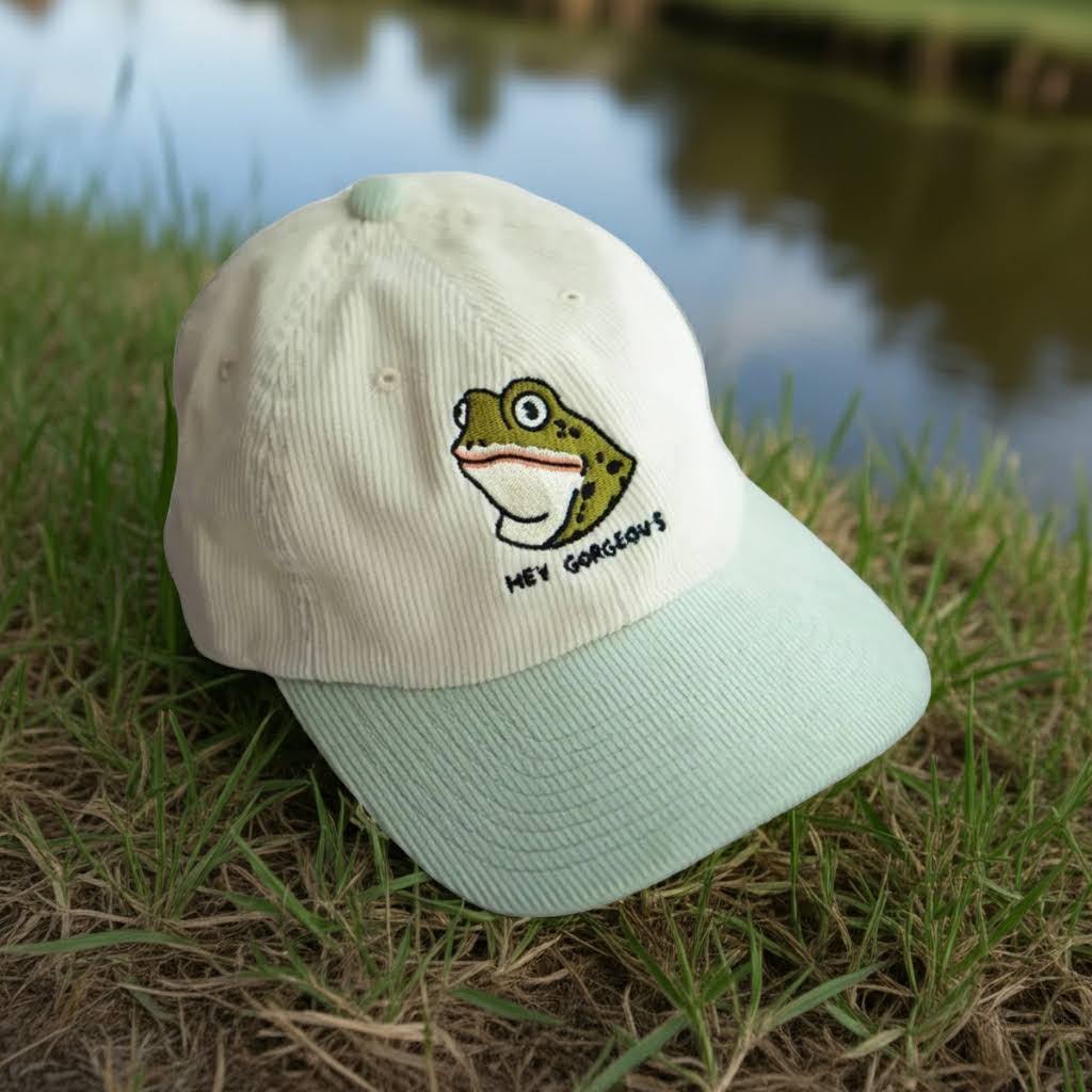 Forager Provisions LTD two-tone corduroy dad hat featuring a frog embroidery with Hey Gorgeous text on grass