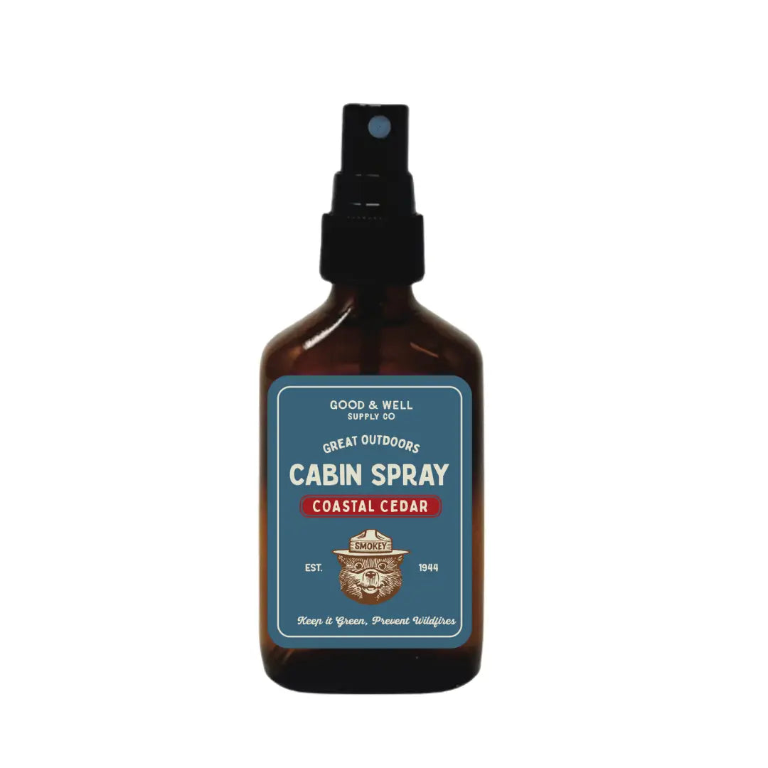 Good & Well Supply Co Coastal Cedar Smokey Bear Cabin Spray brown bottle with blue-red label and black nozzle for home fragrance.