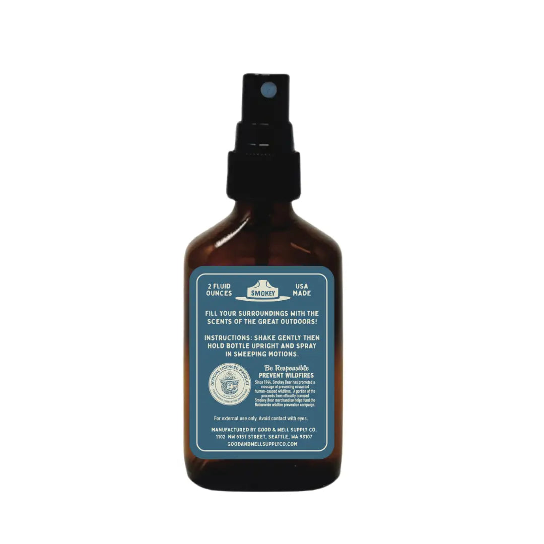 Brown bottle with black nozzle, blue label; Good & Well Supply Co Coastal Cedar Smokey Bear Cabin Room Spray for home fragrance.