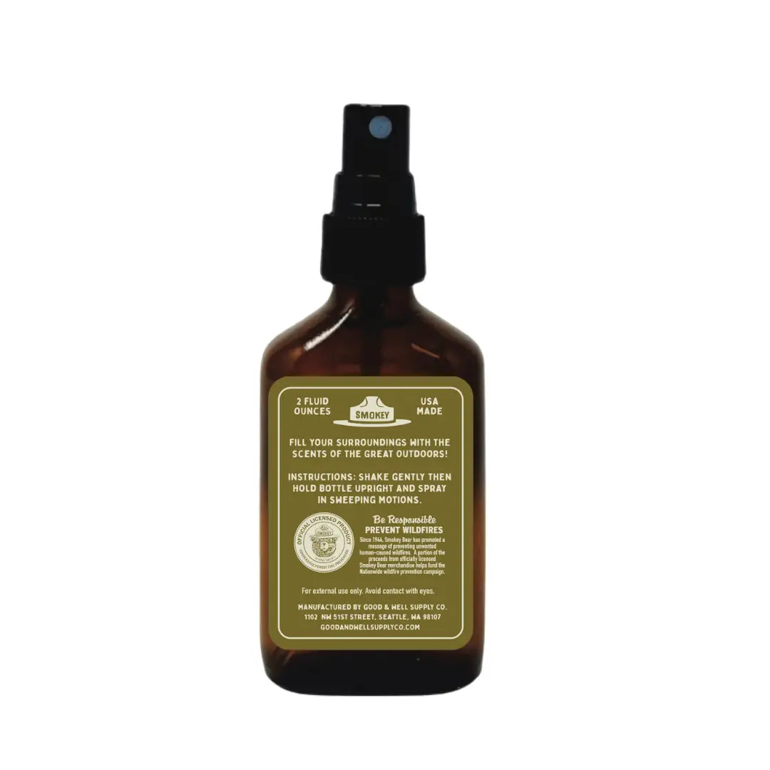 Good & Well Supply Co Desert Pinyon Smokey Bear Cabin Spray bottle with black nozzle, brown glass, and yellow label.