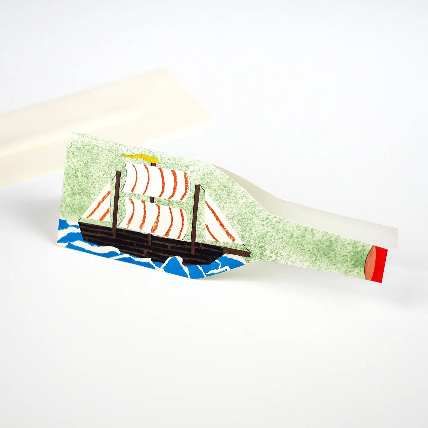 The Hadley Ship In A Bottle Greeting Card features a red sailboat riding blue waves, perfect nautical stationery gift.