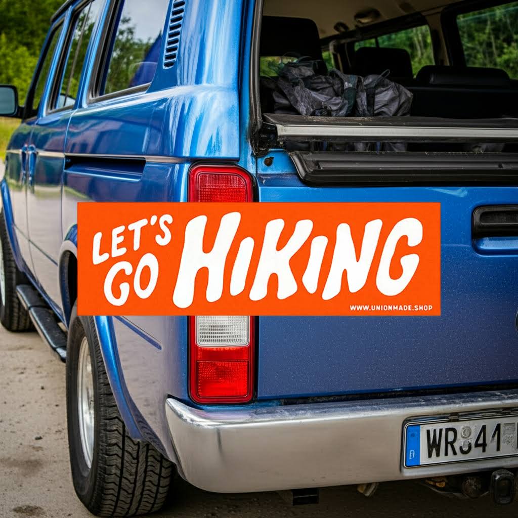Forager Provisions LTD Lets Go Hiking orange vinyl bumper sticker applied to the back of a blue SUV