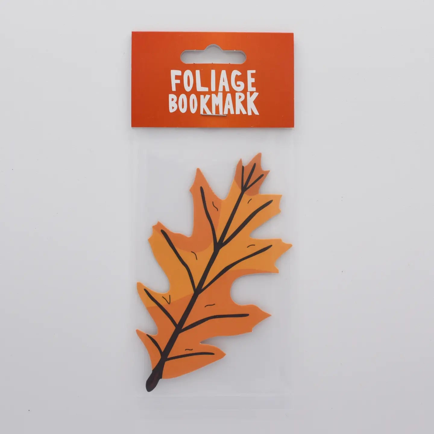 Flat orange Autumn Leaf bookmark by Humdrum Paper, double-sided, in clear packaging with a red header—unique fall gift.
