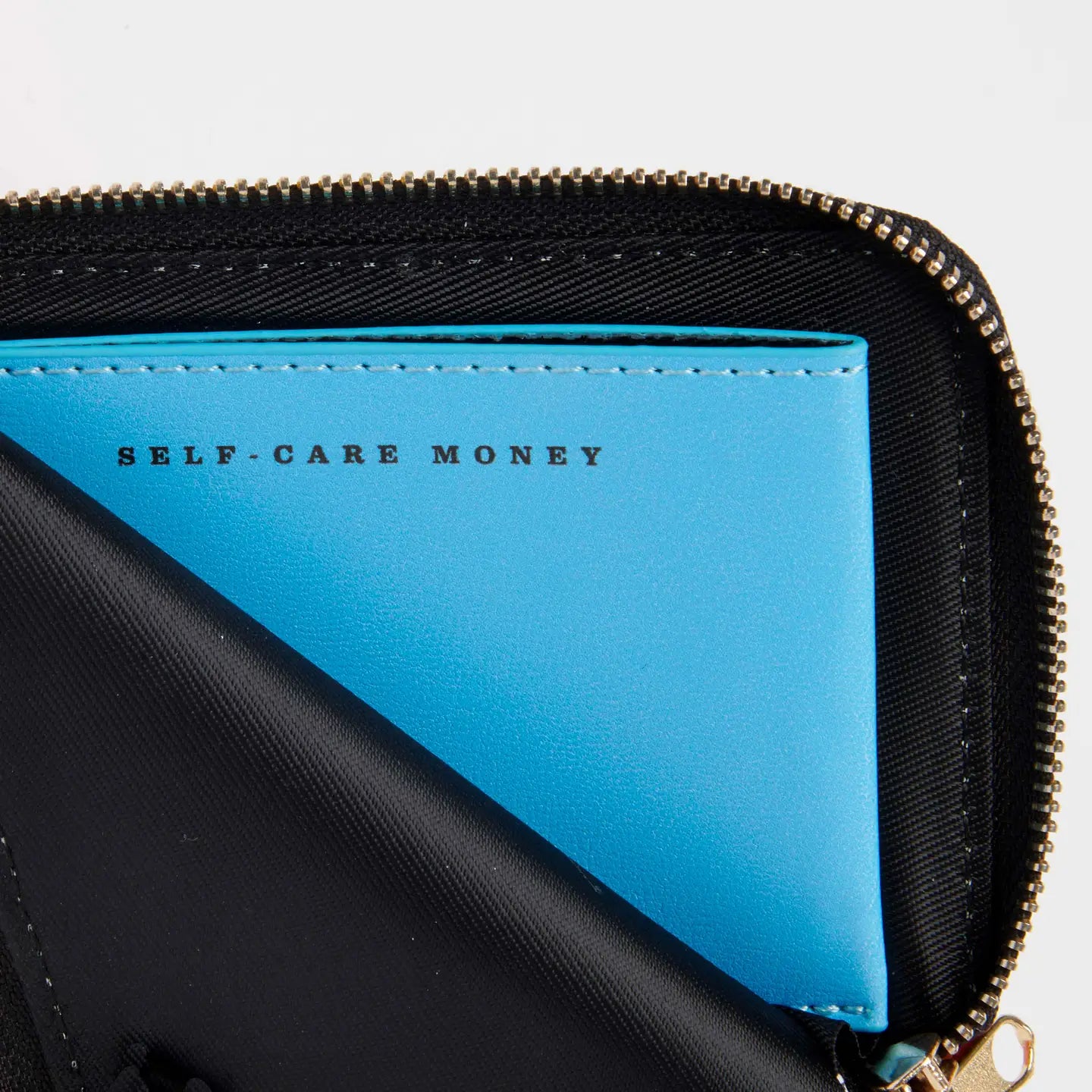 Magpie Peanuts Zip Wallet labeled Self-Care Money peeks from black vegan pleather pouch—chic, ethical, gift idea.