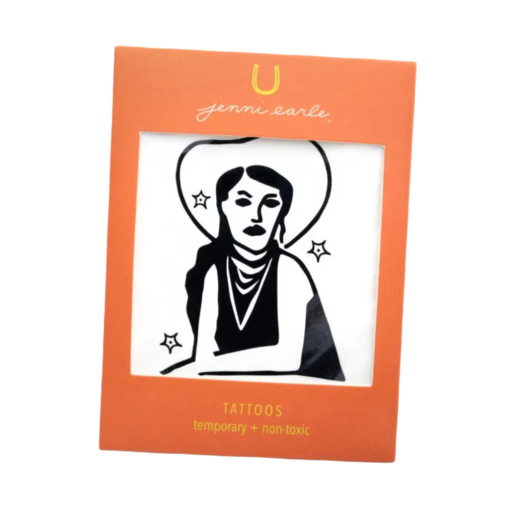 The Jenni Earle Cowgirl Dreamin’ Temporary Tattoo features bold black line art of a person in a hat surrounded by stars, exuding western vibes. It's non-toxic and comes packaged in an orange frame, making it ideal for those Cowgirl Dreamin' days.