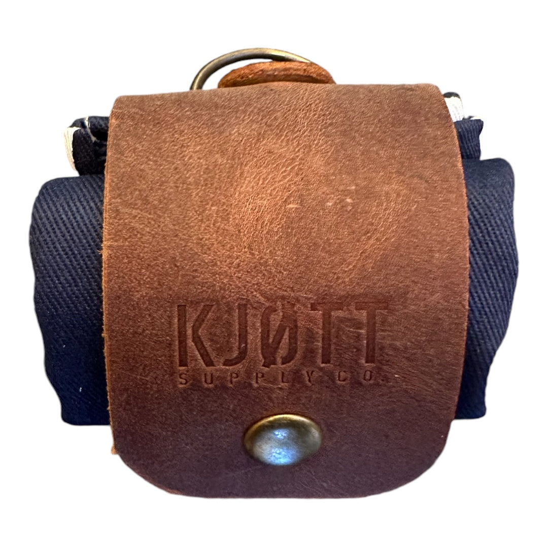 Forager Provisions X Kjøtt Forager Bag: brown leather flap, embossed logo, metal snap closure; premium outdoor gear bag.