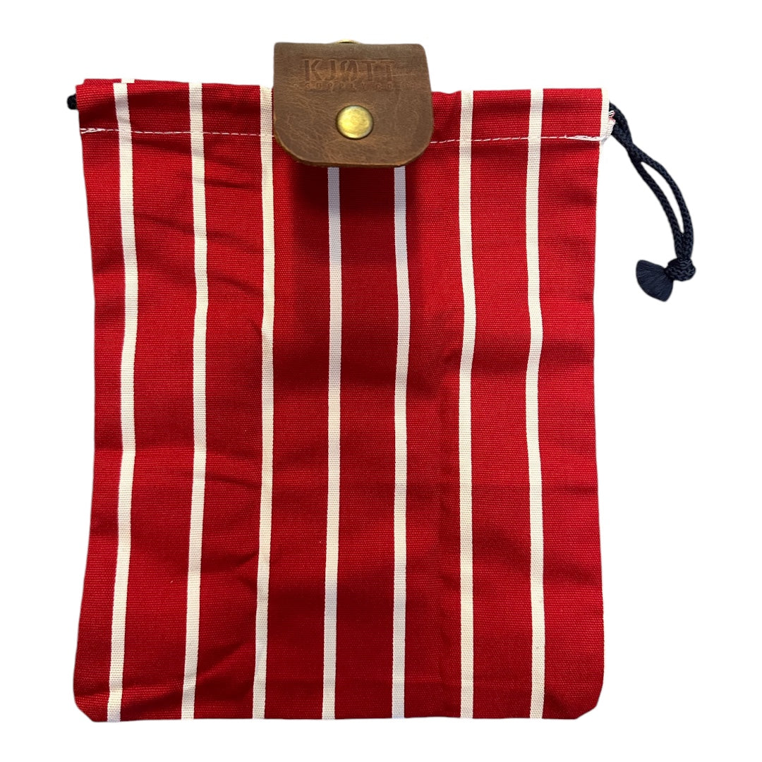 Forager Provisions X Kjøtt Supply Co red striped forager bag with brown leather flap, rugged essentials carrier, outdoors.