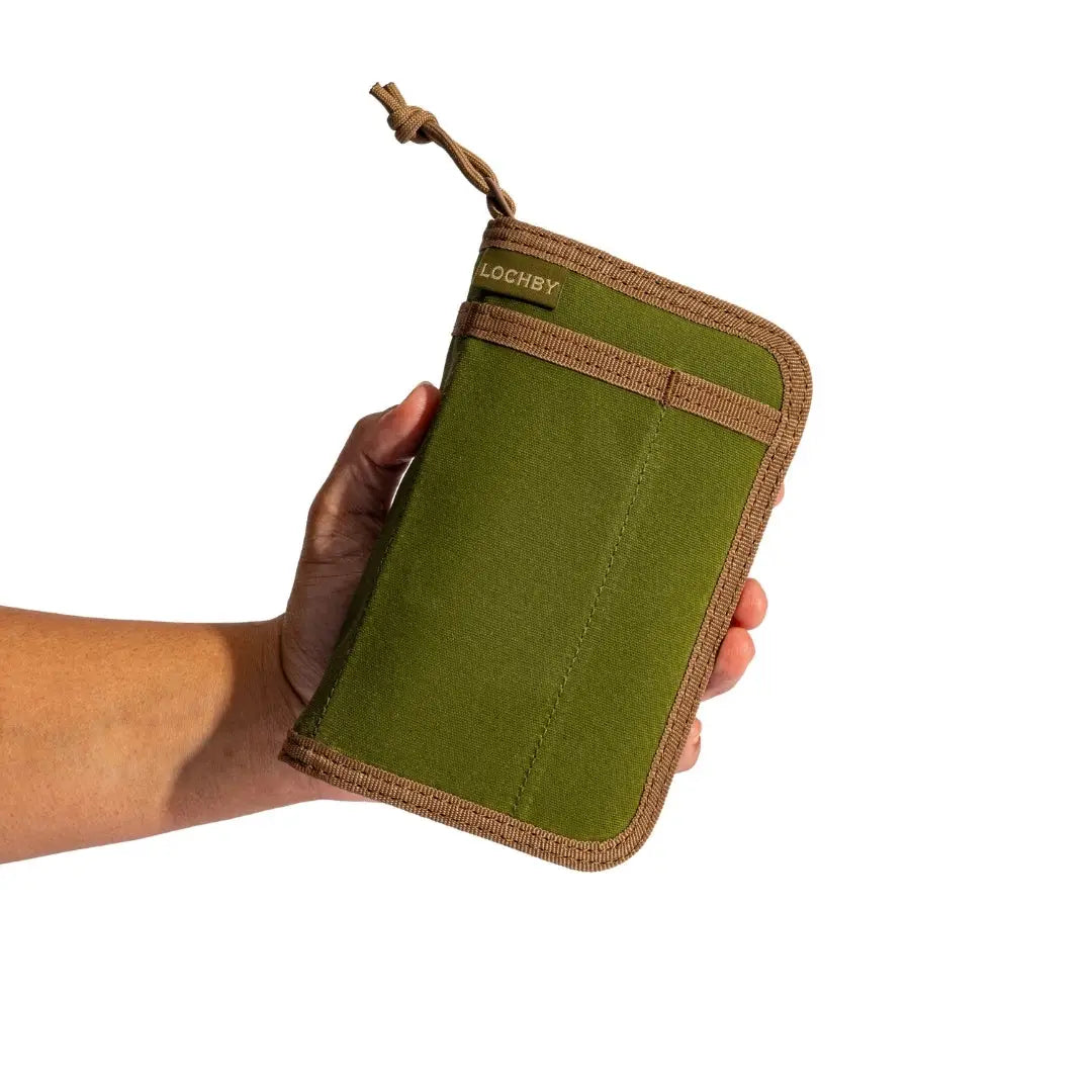 Hand holding Lochby Pocket Journal in Olive color, stationery product displayed on white background, ideal EDC travel notebook.
