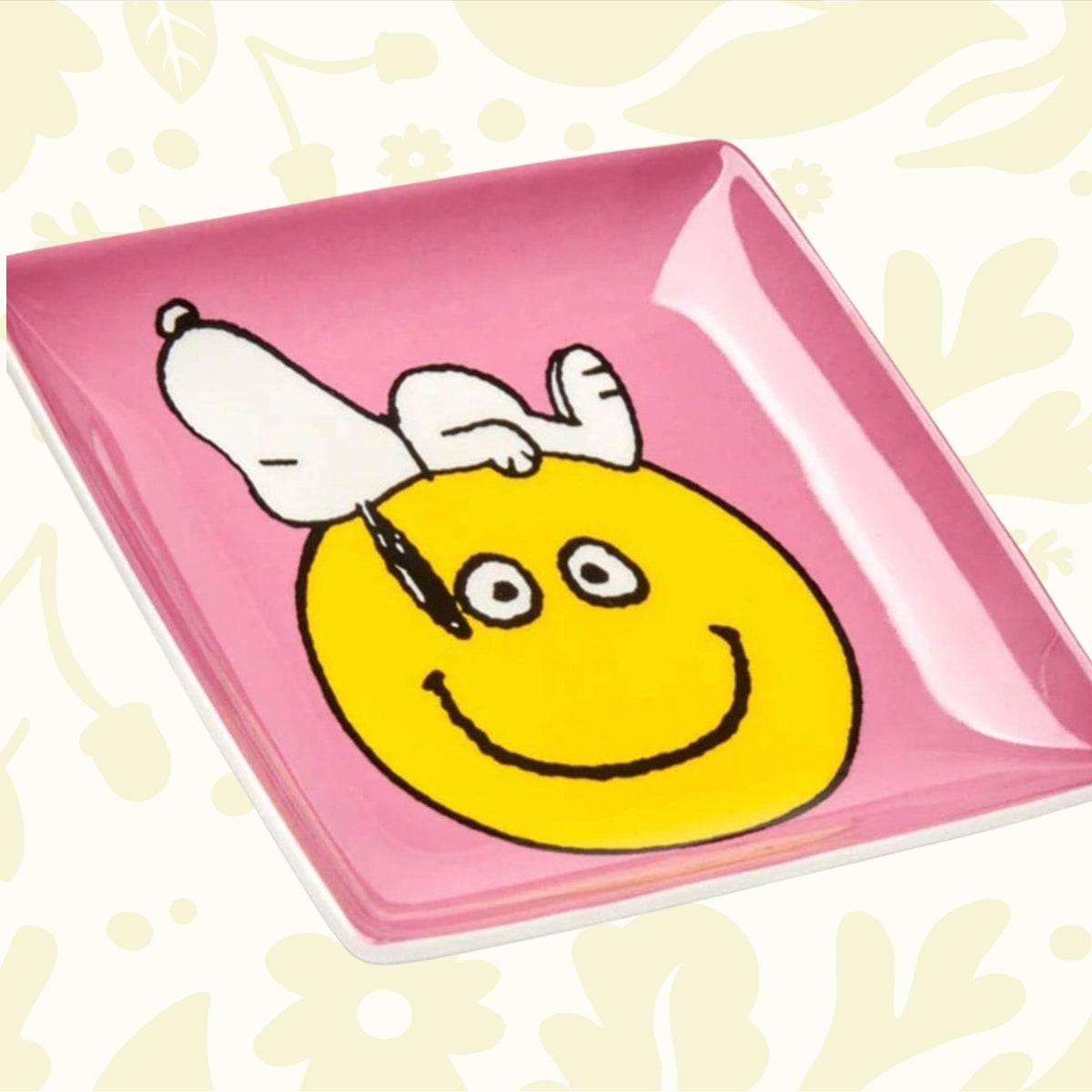 Forager Provisions LTD square pink ceramic trinket tray featuring a yellow smiley face and Snoopy illustration