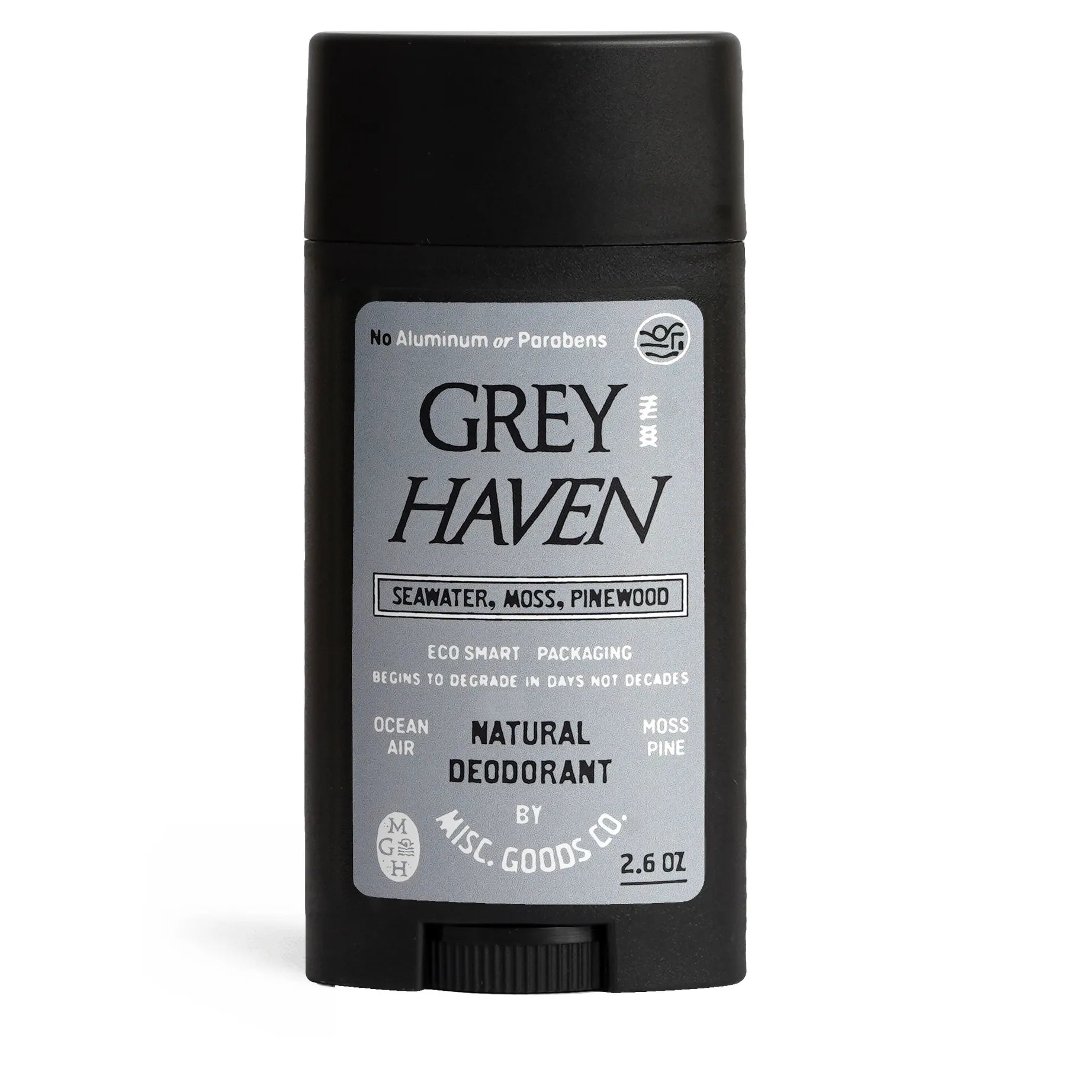A black stick of Misc Goods Co Grey Haven Natural Deodorant, labeled with seawater, moss, and pinewood scent, weighing 2.6 oz. This eco-friendly product is aluminum and paraben free, ensuring effective odor protection all day long.