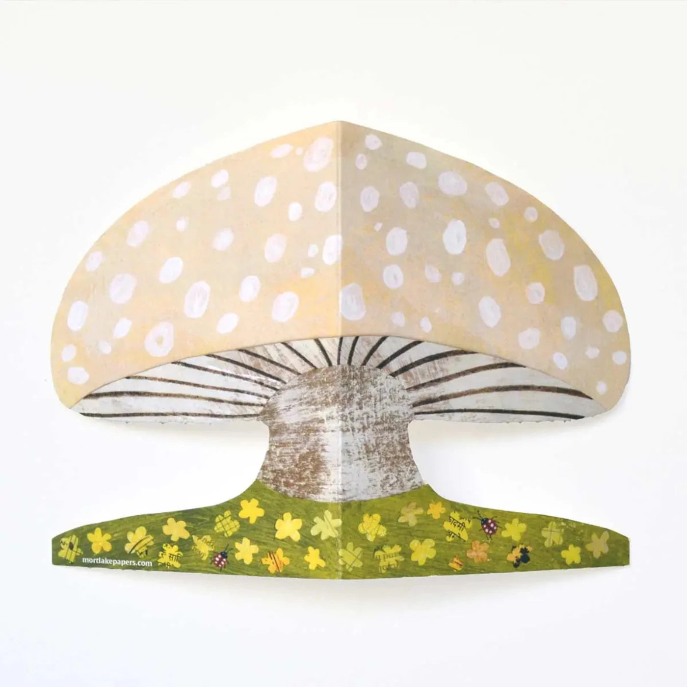 Up close image shows the details of the mushroom shaped greeting card with floral details, ladybirds.
