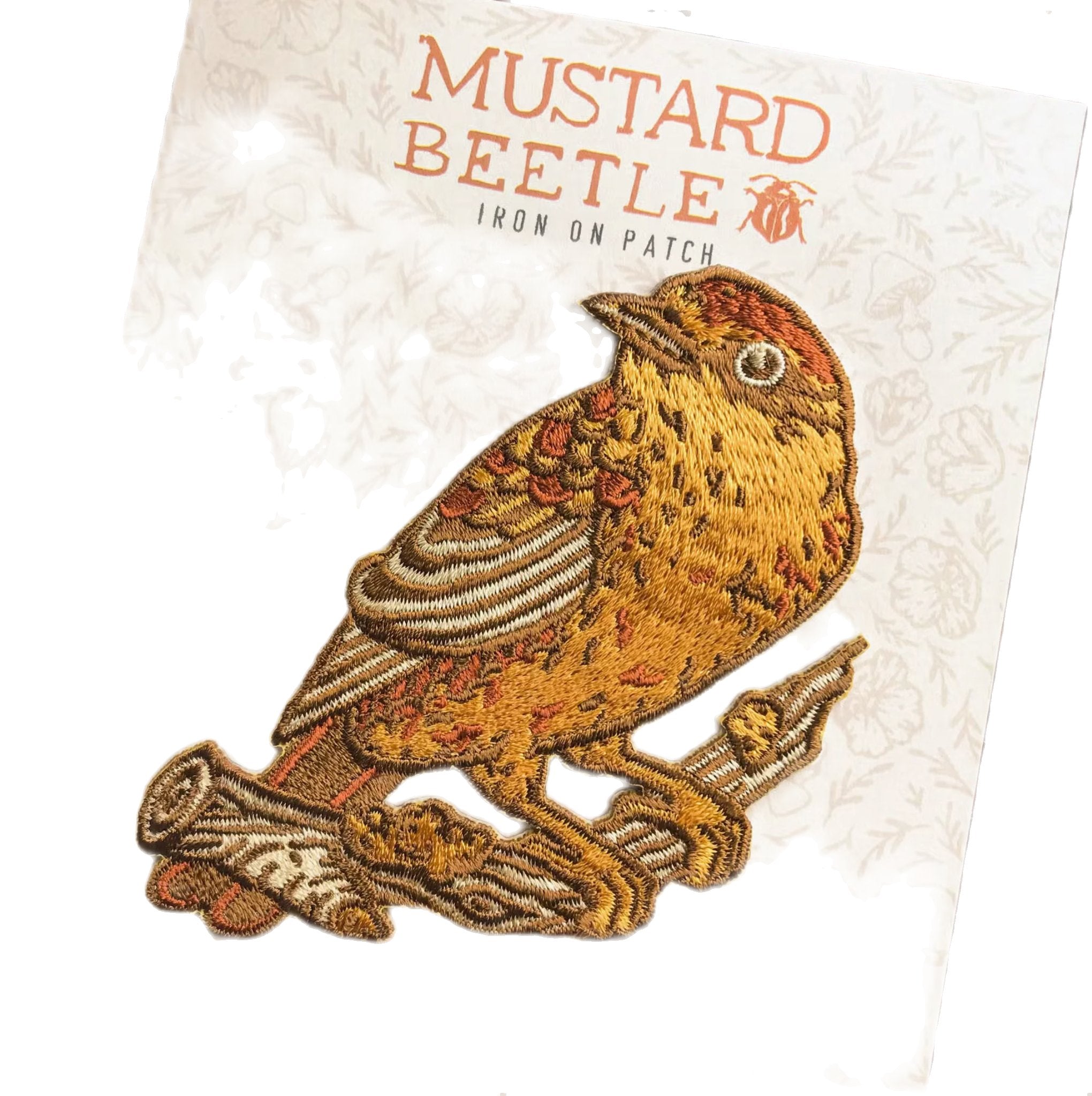 A detailed embroidered patch of a Palm Warbler perched on a branch, displayed on a card with the text "Mustard Beetle Palm Warbler Bird Iron On Patch." This limited edition iron-on embroidered patch makes a charming addition to any collection.