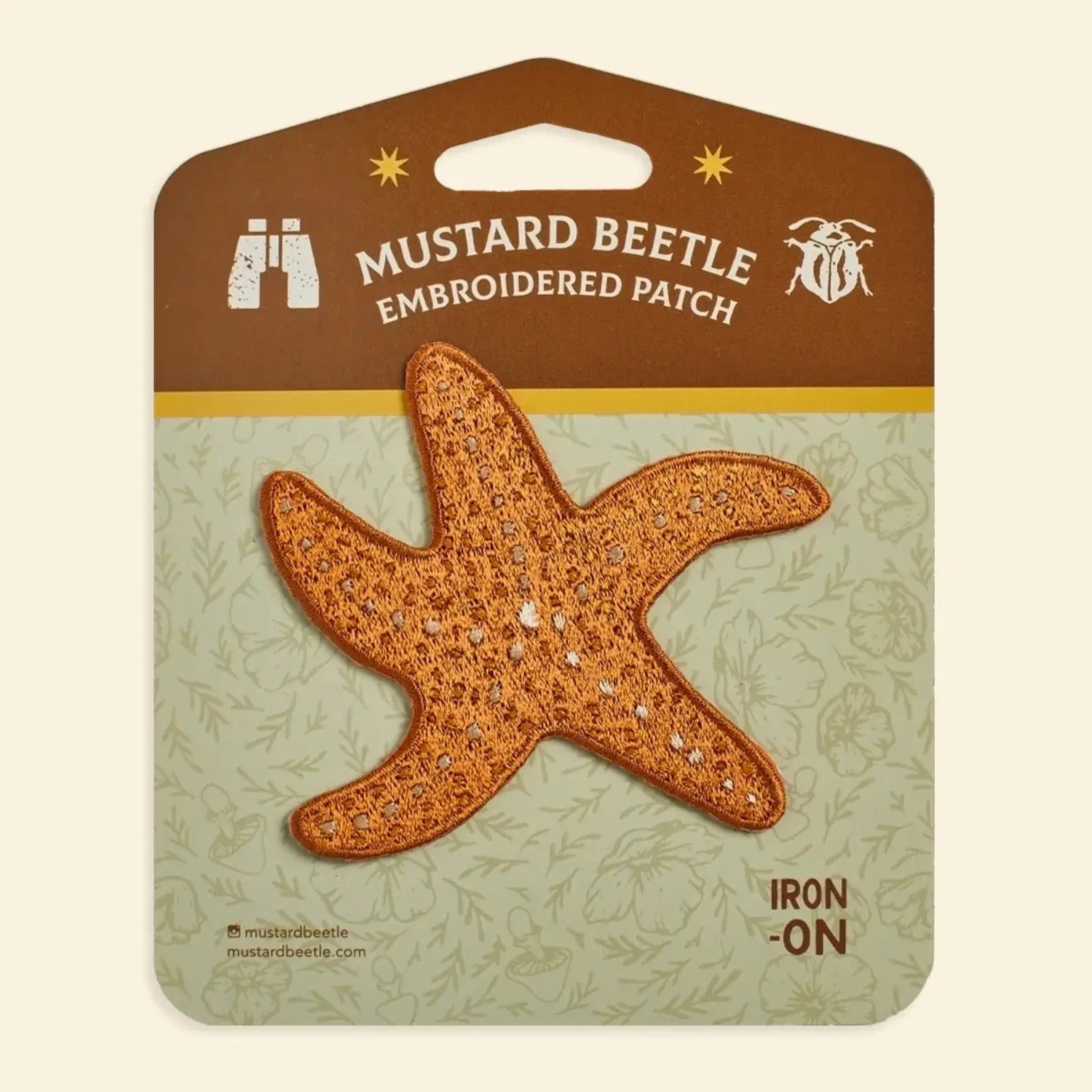 Ochre starfish iron-on patch by Mustard Beetle for marine lovers, displayed on branded card. Unique ocean-themed accessory.