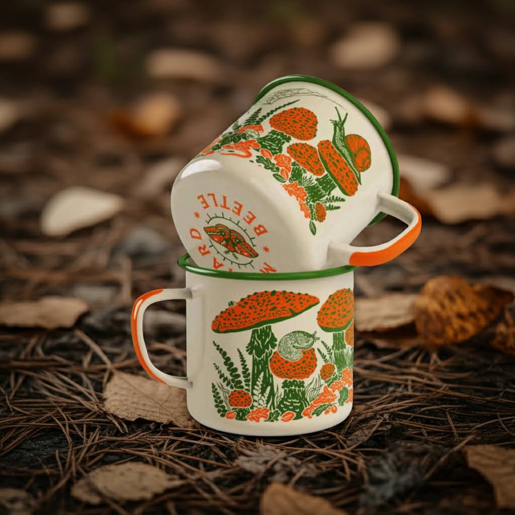 Stacked Mustard Beetle Toad & Mushroom Camp Mugs on forest floor with dry leaves, green foliage—perfect for camping lovers.