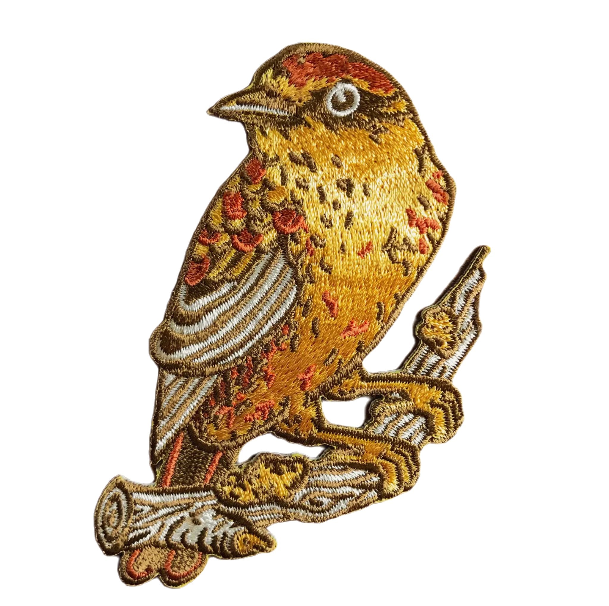 A detailed embroidered patch of a Palm Warbler perched on a branch, displayed on a card with the text "Mustard Beetle Palm Warbler Bird Iron On Patch." This limited edition iron-on embroidered patch makes a charming addition to any collection.