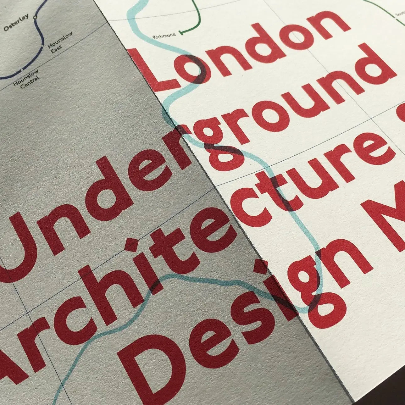 Close-up of a leaflet featuring the Blue Crow Media London Underground Architecture Map, with bold red text "London Underground Architecture Map" over a faint map background, highlighting the intricate details of transport design.