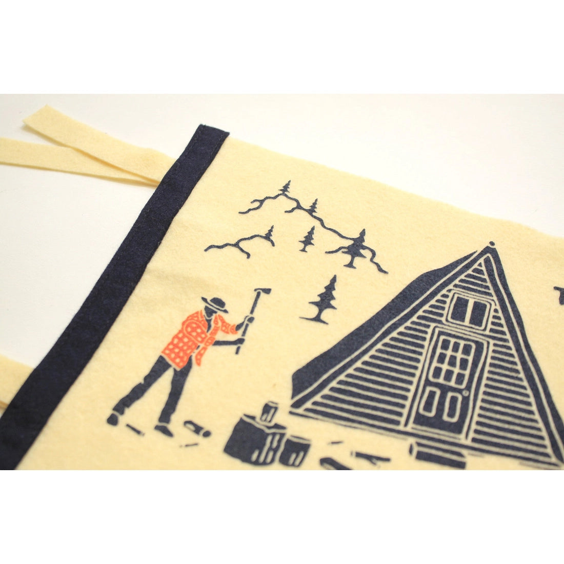 A yellow Oxford Pennant "No Substitute For Hard Work" custom pennant, made from wool felt, features an illustration of a cabin, trees, mountains, and a person with the text "There is no substitute for hard work.