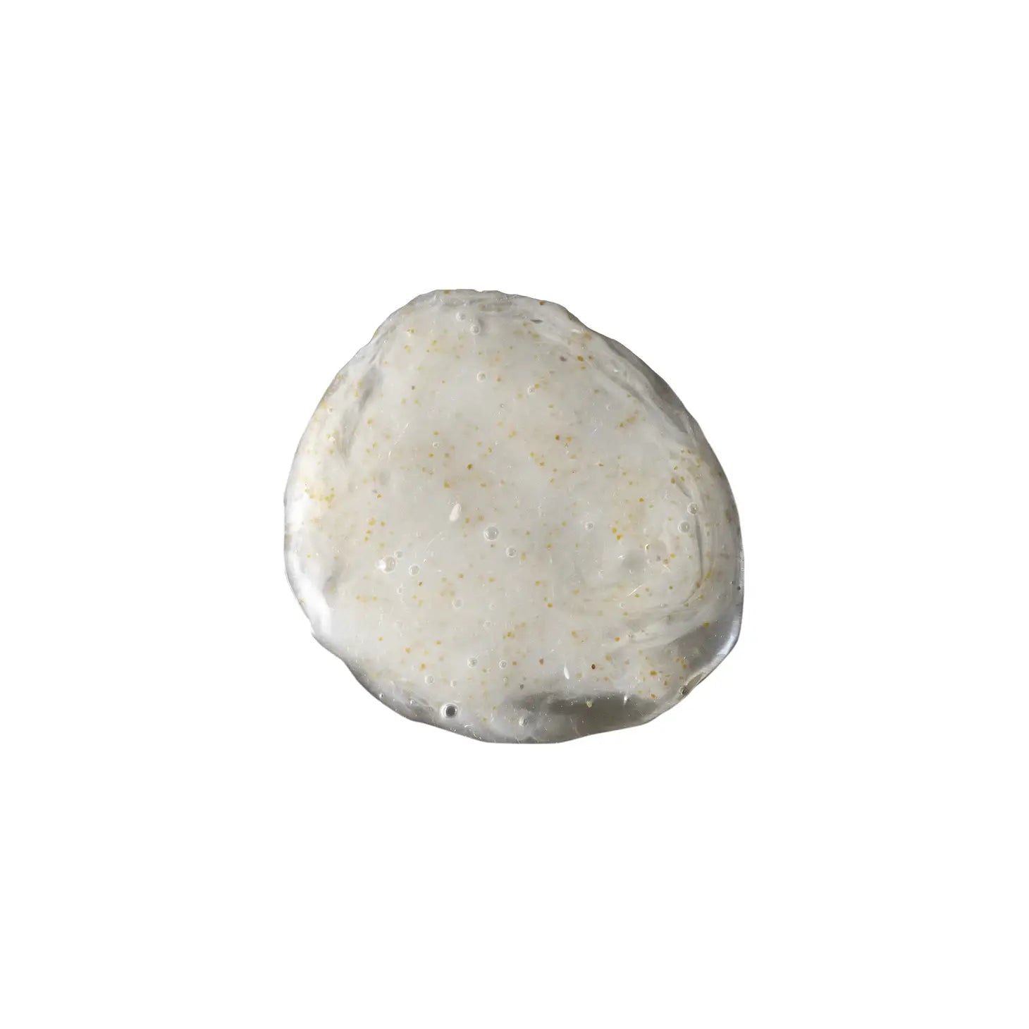 A round, smooth, white exfoliating hand cleanser with a slightly uneven texture and small specks of walnut shell displayed on a white background.