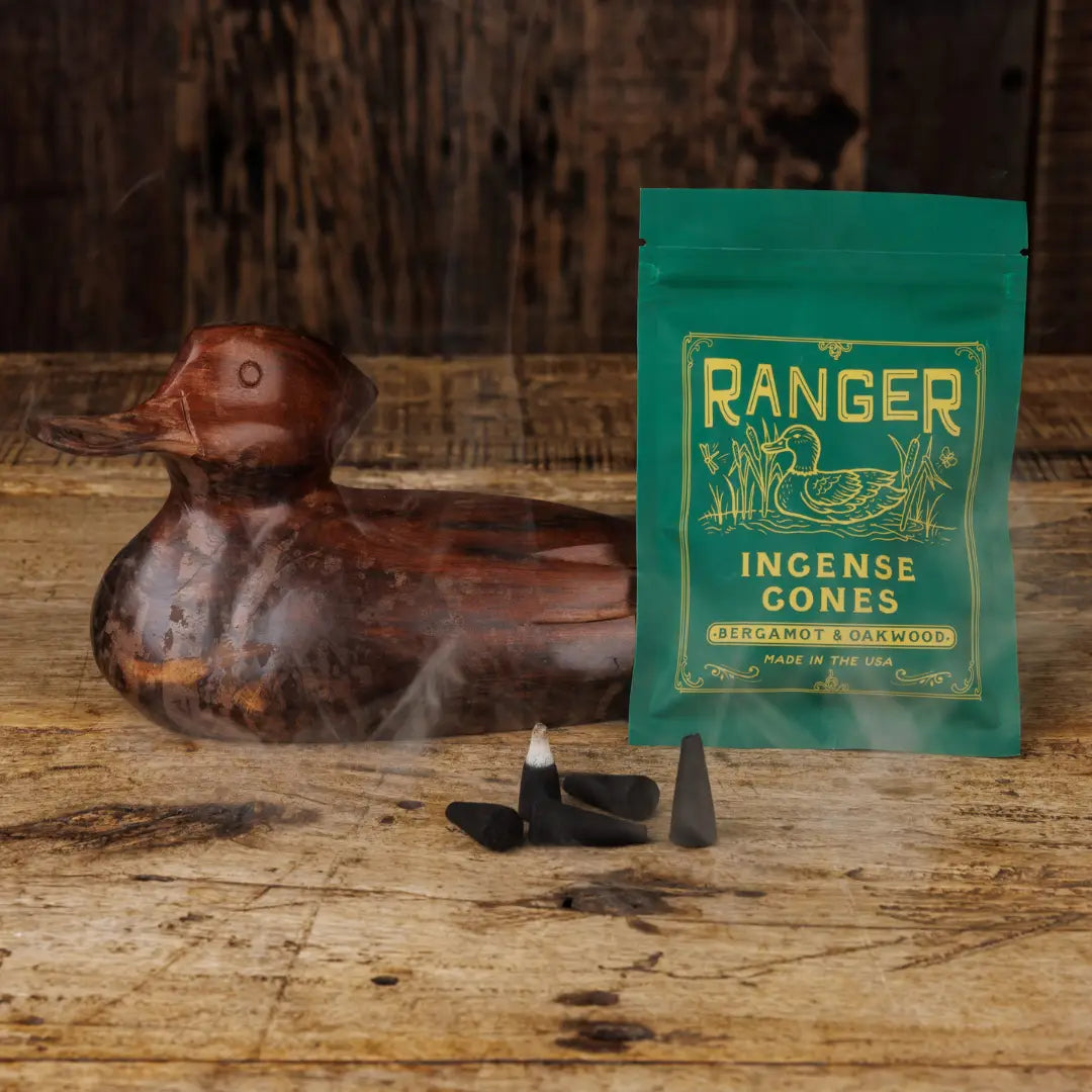 Wood duck decor, Good & Well Supply Co Ranger incense cones, and green bag with smoke on rustic wood surface.