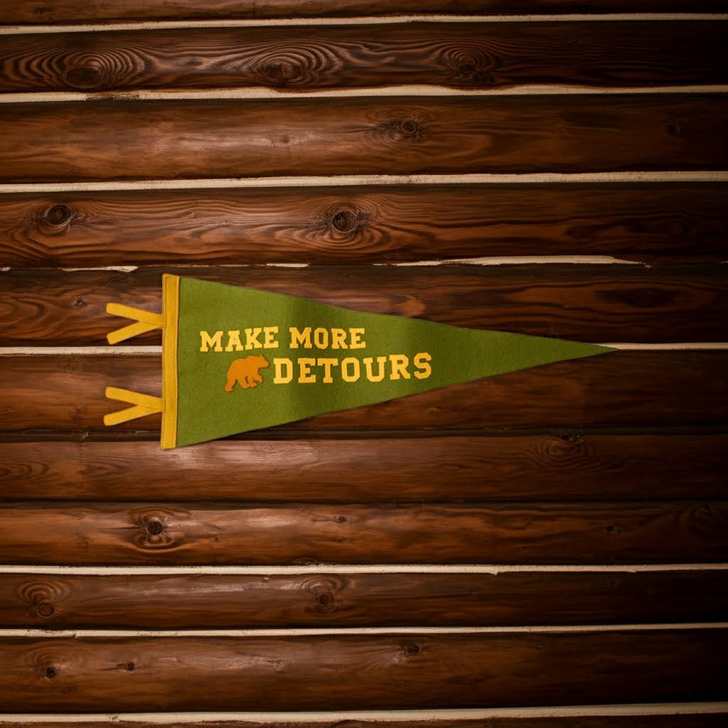 Forager Provisions LTD wool felt pennant in olive green with Make More Detours text and bear icon on wood wall