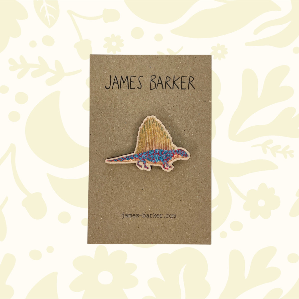 Colorful eco-friendly James Barker Dimetrodon dinosaur wooden pin on a branded card; unique prehistoric gift for collectors.