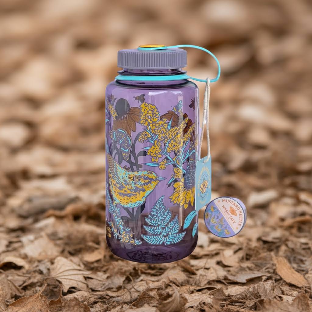 Mustard Beetle Prairie 32oz Nalgene water bottle with bird and flower print, purple lid, on dry leaves, brand tag visible.