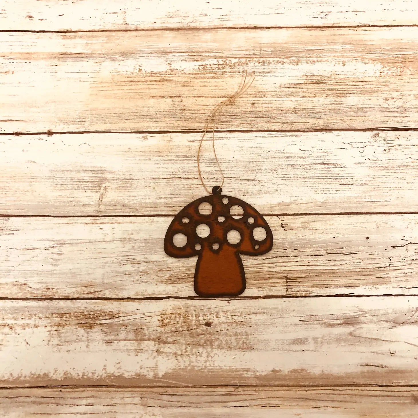 Universal Ironworks Redcap Mushroom Hanging Decoration suspended by string, displayed on white wooden background farmhouse decor.