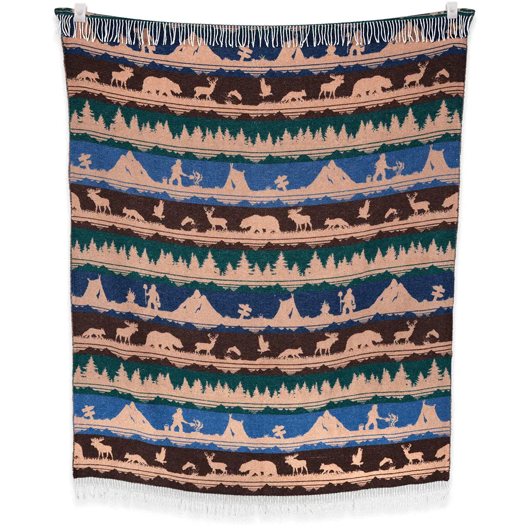 A Sackcloth & Ashes Smokey Bear Blanket - Smokey Dungaree, featuring woven rows with wilderness scenes of trees, mountains, bears, deer, and human figures in neutral tones.