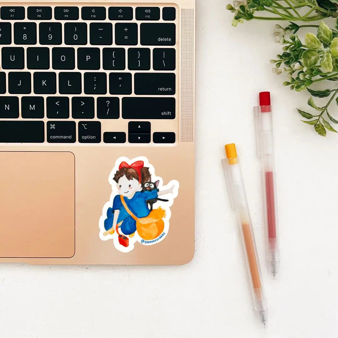 The Seenee Scribbles Studio Ghibli Inspired Kiki Delivery Service Sticker features a charming cartoon girl in a blue outfit with a red bow, holding a broomstick and accompanied by an adorable black cat. Encircled by green leaves on a wooden surface, she evokes the enchanting essence of Kiki's Delivery Service. Ideal for vinyl stickers!