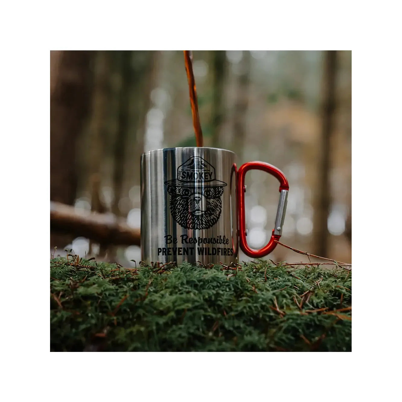 The Smokey Bear Carabiner Handle Mug - Be Responsible showcases a metal mug with a red carabiner handle and features an image of Smokey Bear wearing a hat along with the message "Smokey: Be Responsible, Prevent Wildfires.
