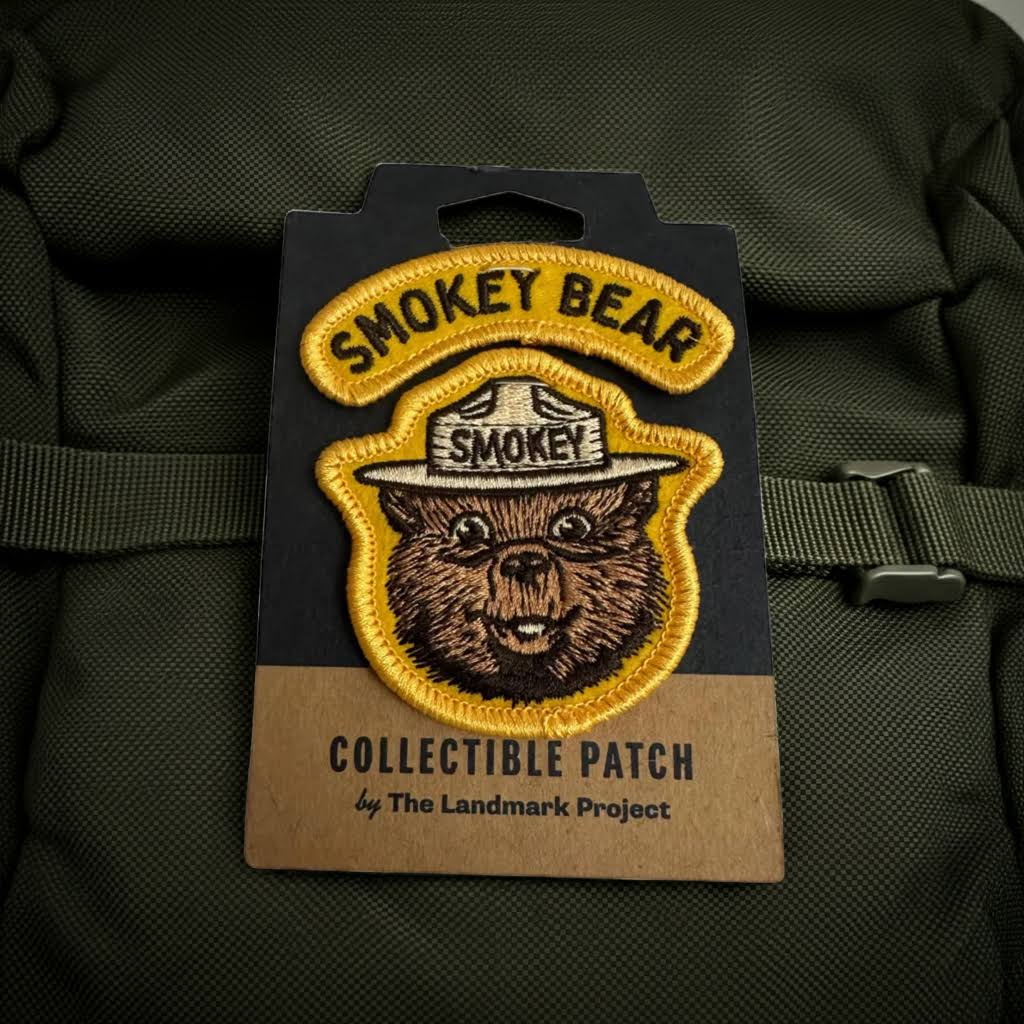 Forager Provisions LTD Smokey Bear embroidered varsity patch on a green backpack, featuring classic bear artwork.
