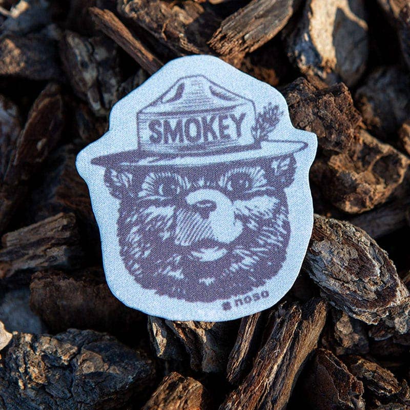 Forager Provisions LTD Smokey Bear vintage logo peel-and-stick repair patch on a rustic bark background