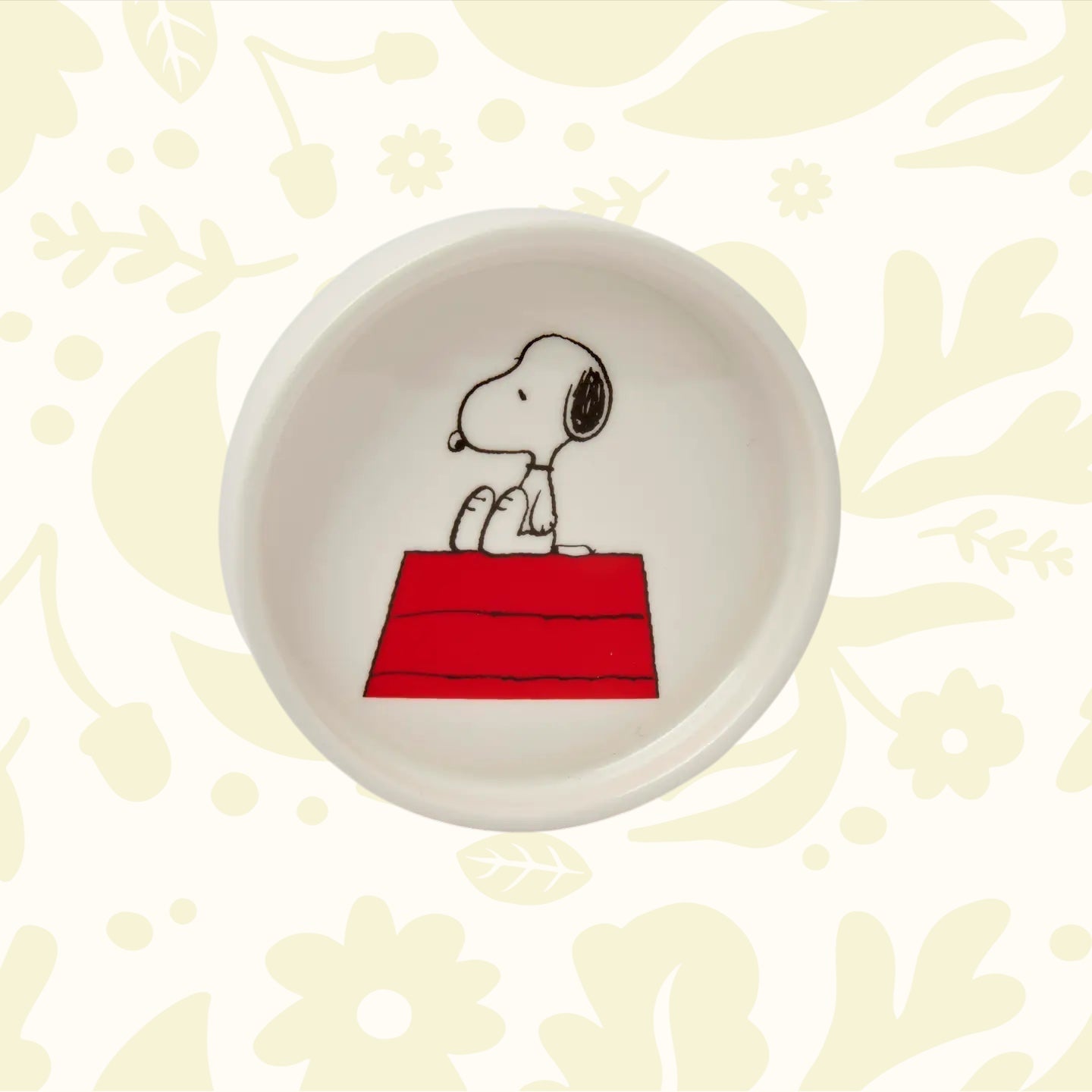 Snoopy sits on his red doghouse on The Magpie Peanuts Home Sweet Home round trinket dish—perfect Snoopy gift or home decor.