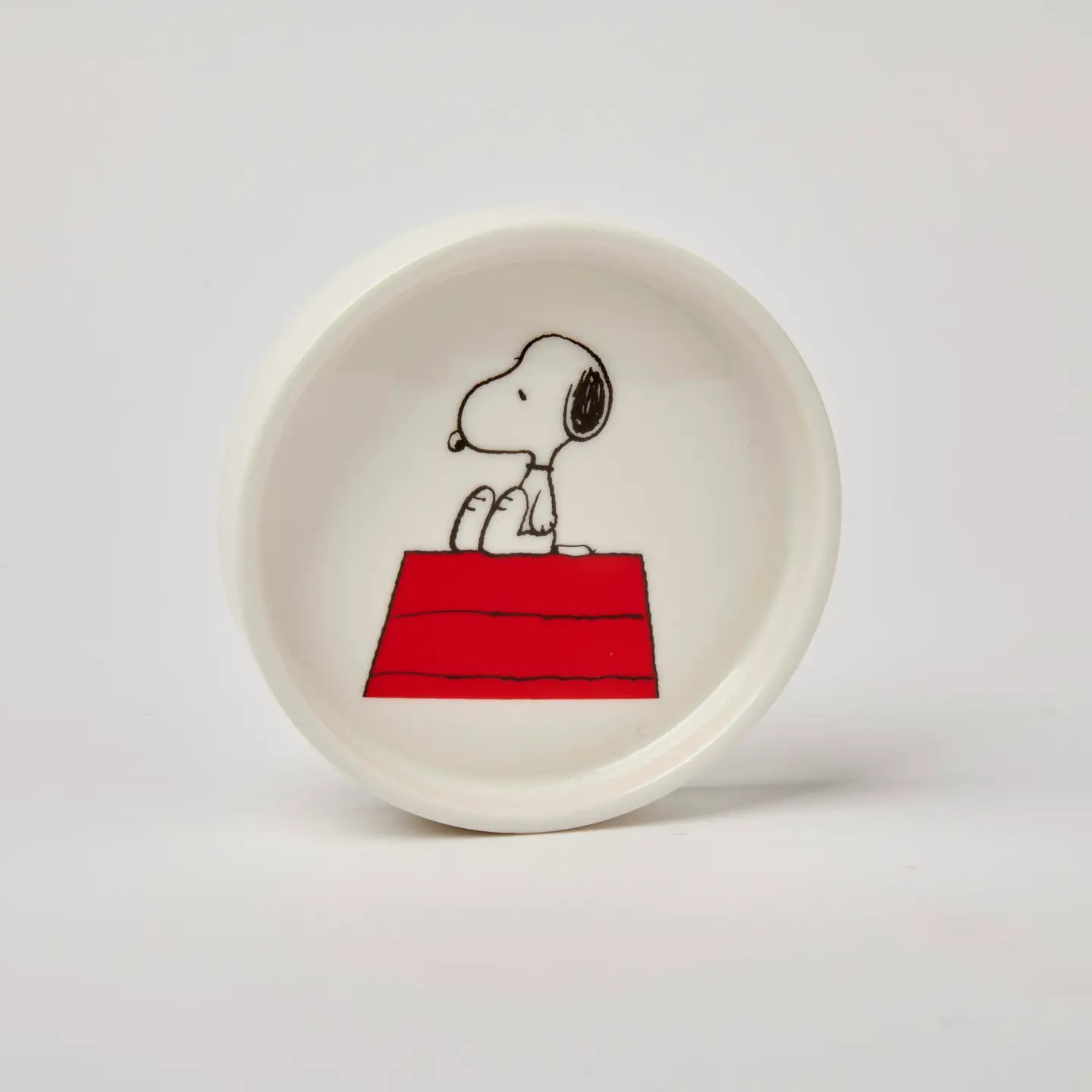 Snoopy sits on his red doghouse on The Magpie Peanuts Home Sweet Home round trinket dish—perfect Snoopy gift or home decor.