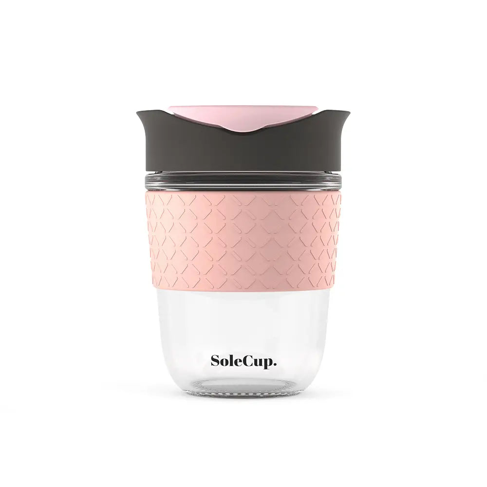 12oz Sole Cup travel mug: tempered glass, pink silicone grip, black lid. Eco-friendly reusable coffee cup for on-the-go.
