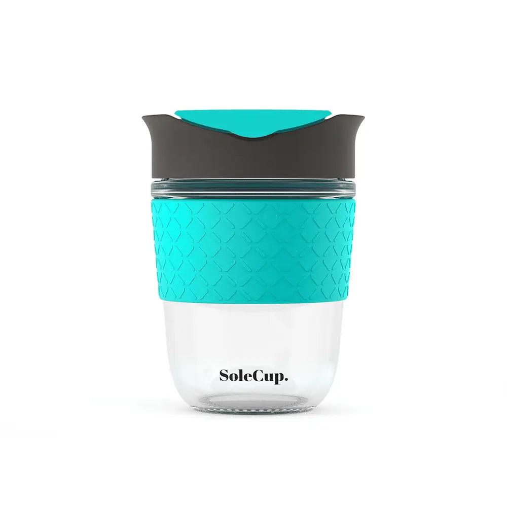 Sole Cup 12oz tempered glass travel mug with turquoise silicone grip, black lid, and visible Sole Cup logo on front.