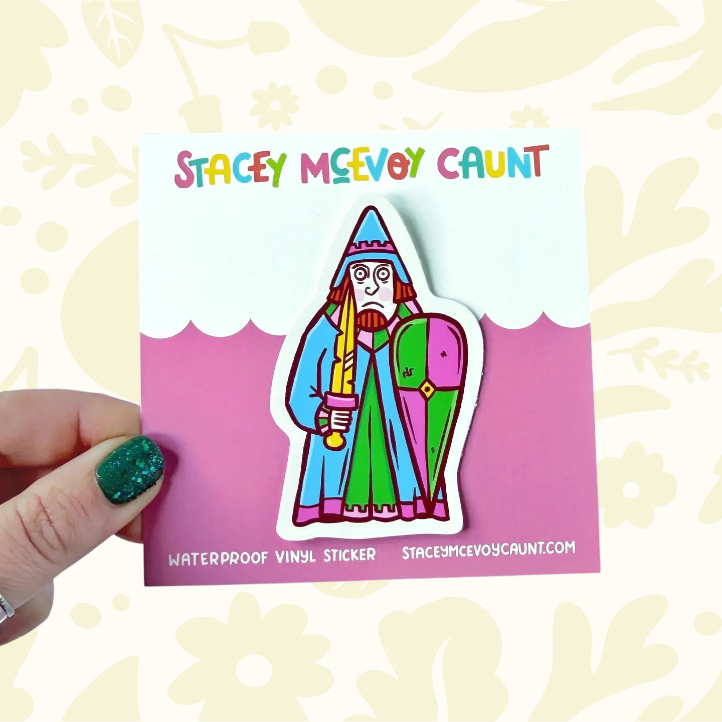 Hand displays Stacey McEvoy Caunt medieval rook Lewis chessmen vinyl sticker, branded card, plus colorful stationery in background.
