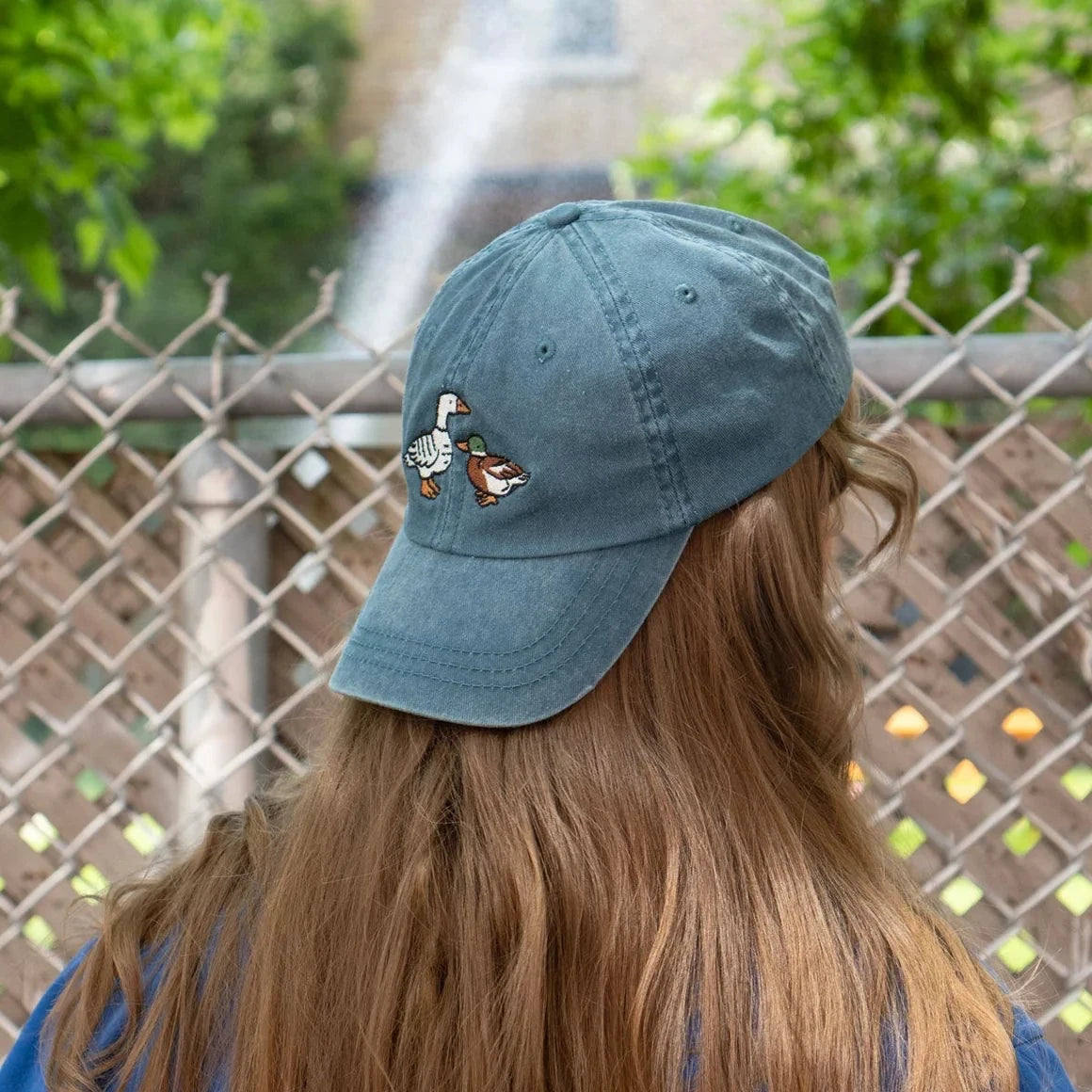 Person models the Stay Home Club Fowl Dad Cap in Vintage Teal, a trendy bird embroidered hat, perfect for casual streetwear style.