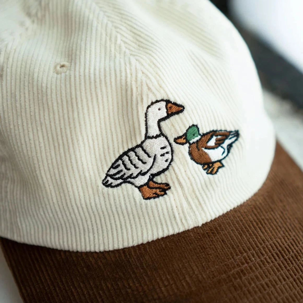 Shop The Stay Home Club Fowl Two Tone Cord Cap with unique goose and duck embroidery, trendy adjustable corduroy baseball hat.