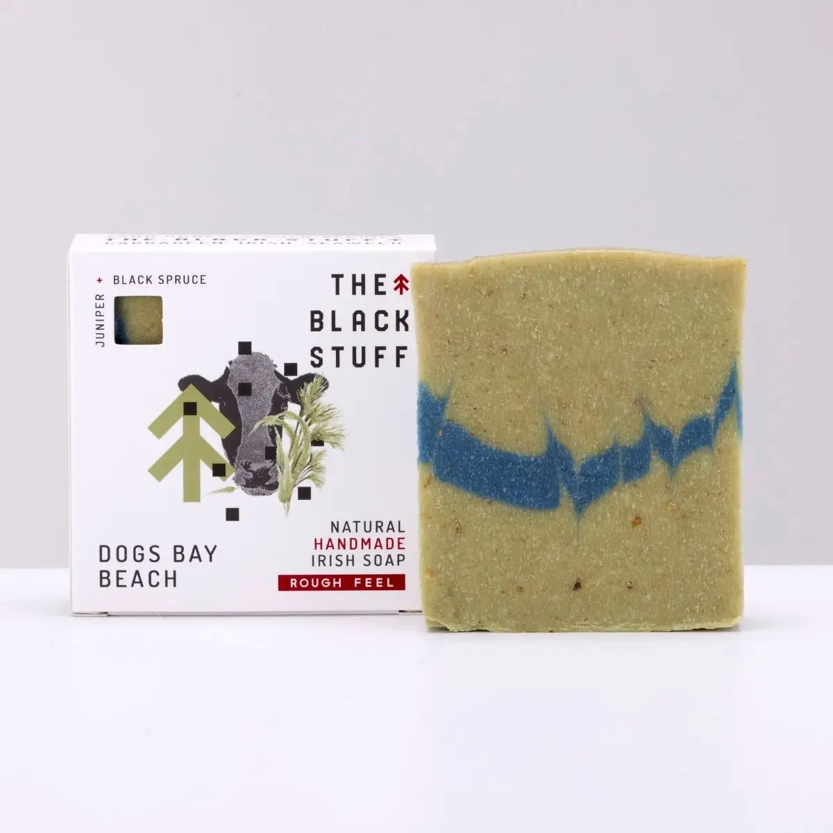 Eco-friendly soap bar with blue stripe beside The Black Stuff Soap - Dogs Bay Beach box, natural skincare product.